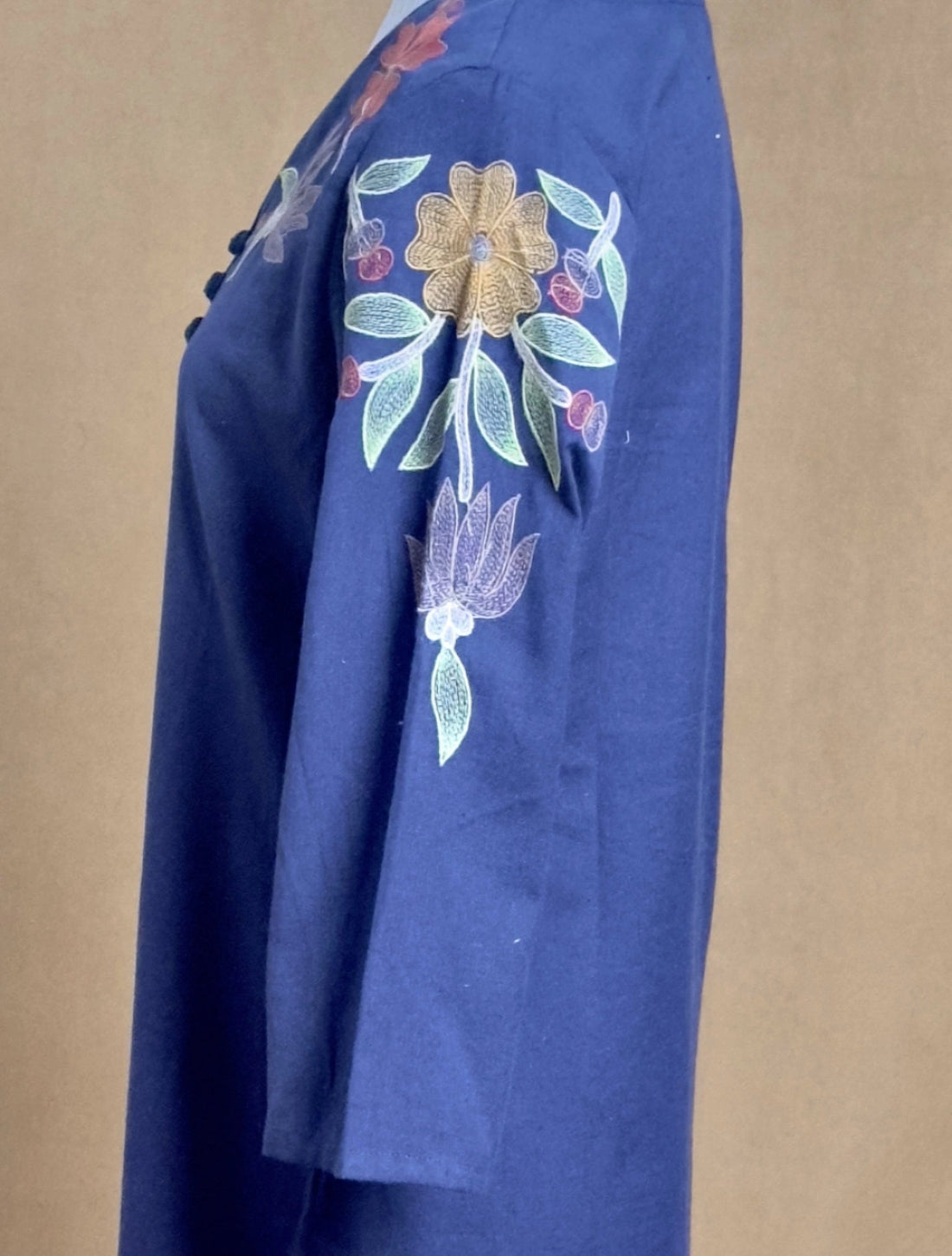 Blue fabric with floral embroidery on a beige background