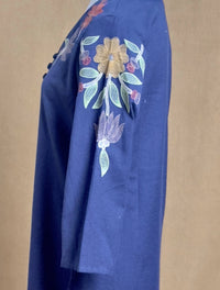 Blue fabric with floral embroidery on a beige background