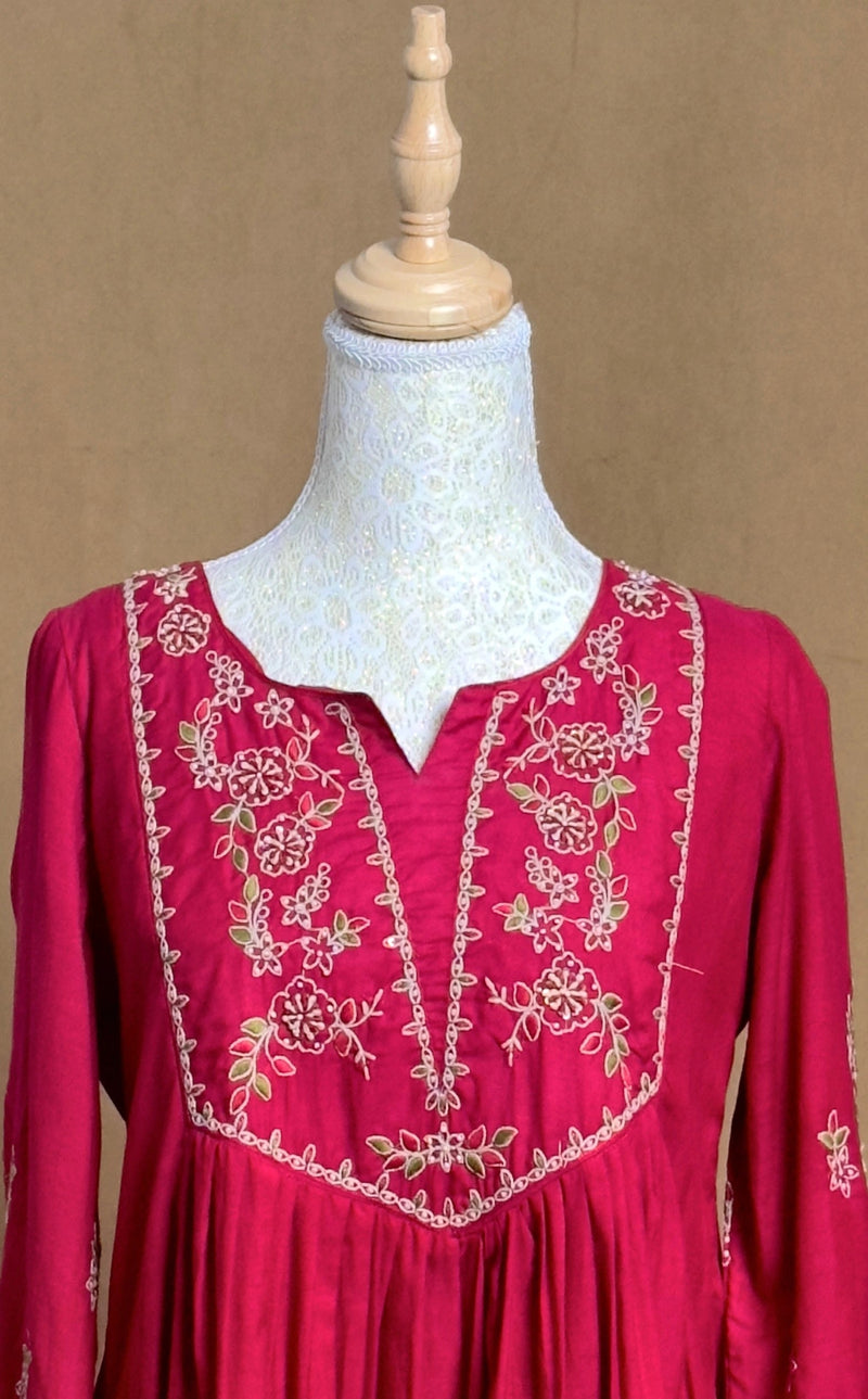 Red dress with floral embroidery on a mannequin against a brown background