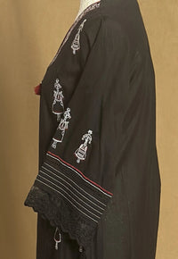 Black embroidered garment on a beige background