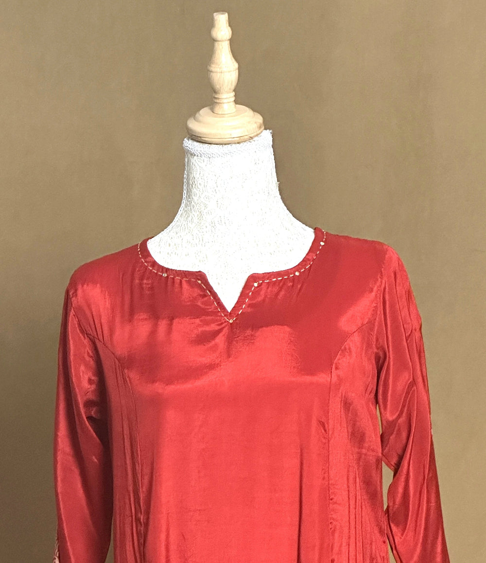 Red satin blouse on a mannequin against a beige background