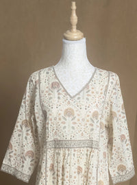 Floral patterned blouse on a mannequin against a brown background