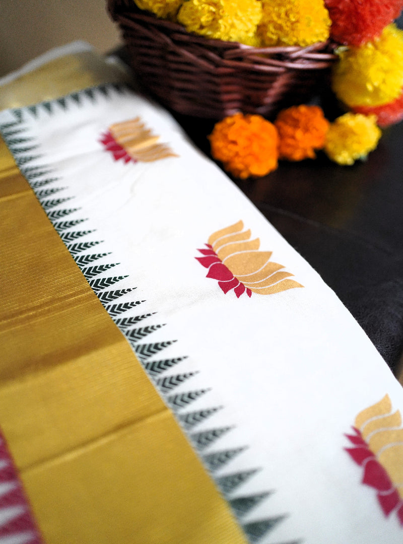 Traditional saree with floral patterns and a basket of marigold flowers on a dark surface