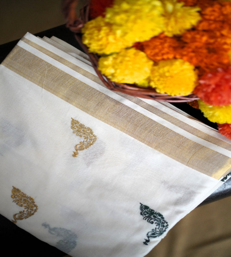 White fabric with embroidered patterns next to a basket of marigold flowers