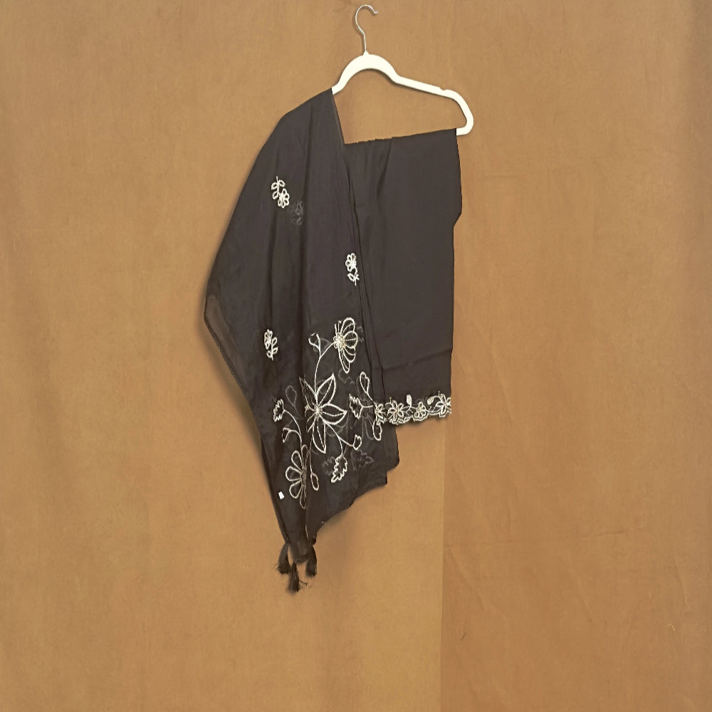 Black embroidered scarf on a hanger against a brown background