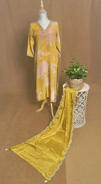 Yellow dress on a mannequin with a plant on a brown background