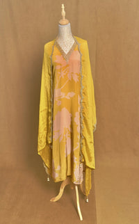 Yellow floral dress on a mannequin against a brown background