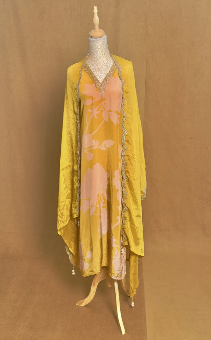 Yellow floral dress on a mannequin against a brown background