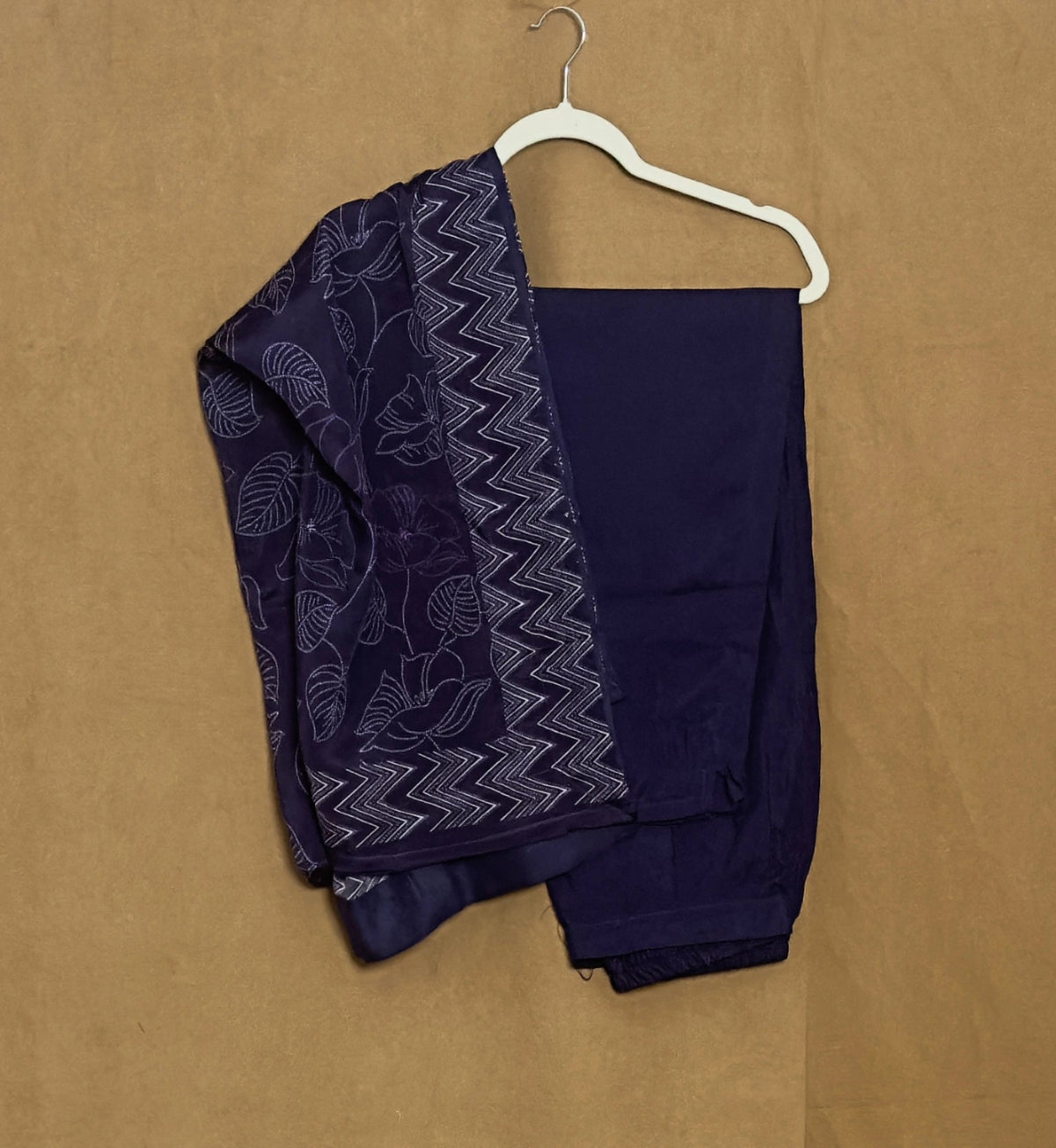 Navy blue saree with white patterns on a beige background