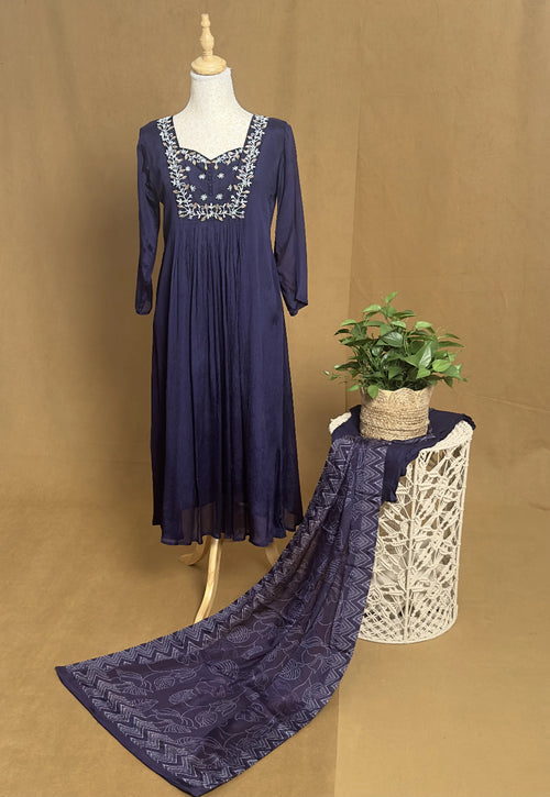 Navy blue dress with lace details on a mannequin against a brown background