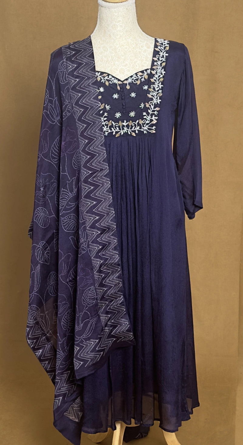 Navy blue dress with lace details on a mannequin against a brown background