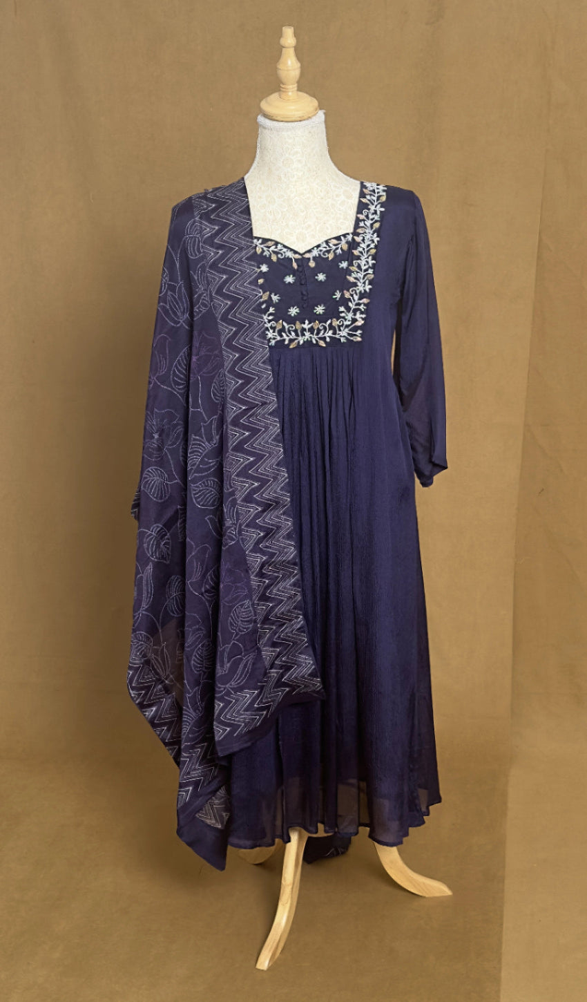 Navy blue dress with lace details on a mannequin against a brown background