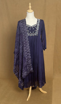 Navy blue dress with lace details on a mannequin against a brown background