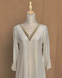 White lace dress on a mannequin against a brown background