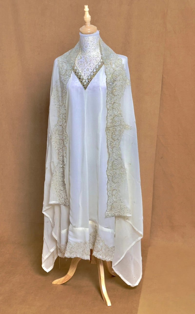 White lace dress on a mannequin against a brown background