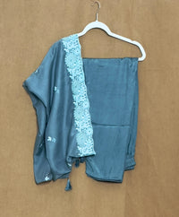 Blue dress  with lace border on a hanger against a brown background