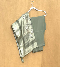 dress pant and shawl  on a hanger against a beige background