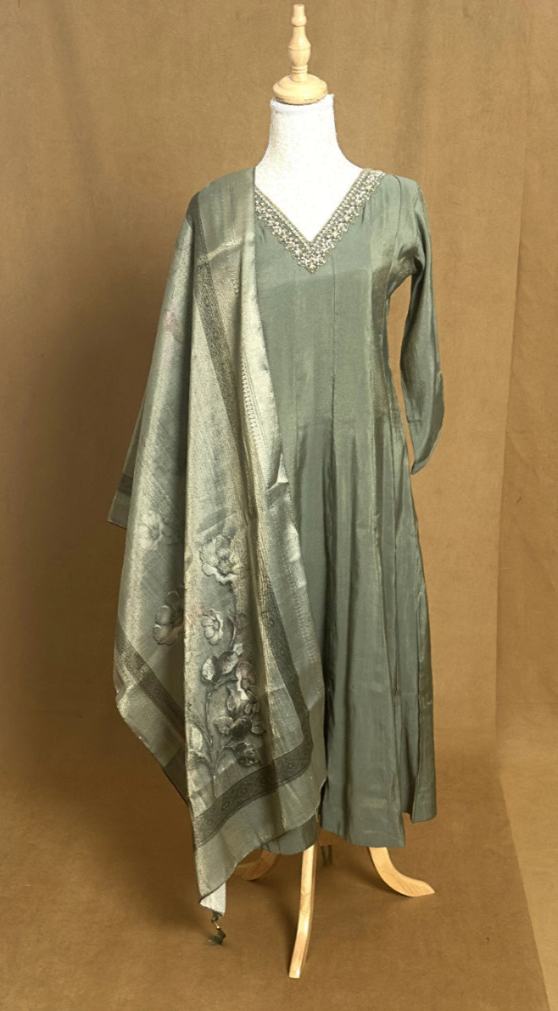 Green dress with a matching dupatta on a mannequin against a brown background