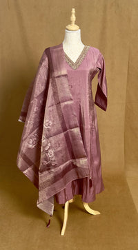 Purple dress with a pattern on a mannequin against a brown background