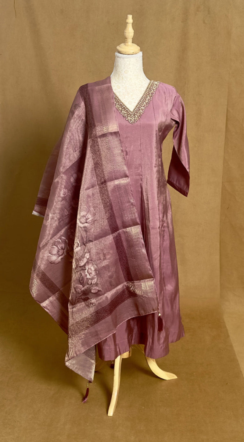 Purple dress with a pattern on a mannequin against a brown background