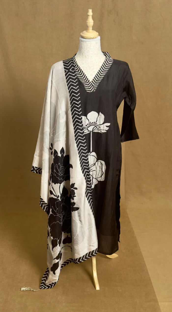 Mannequin wearing a black and white floral dress with a geometric pattern on a brown background