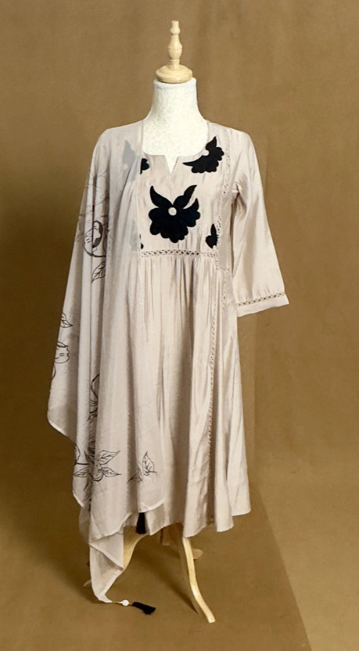 Mannequin wearing a beige dress with black floral patterns on a brown background