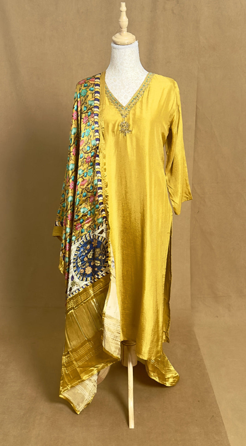 Yellow dress with a colorful patterned scarf on a mannequin against a brown background