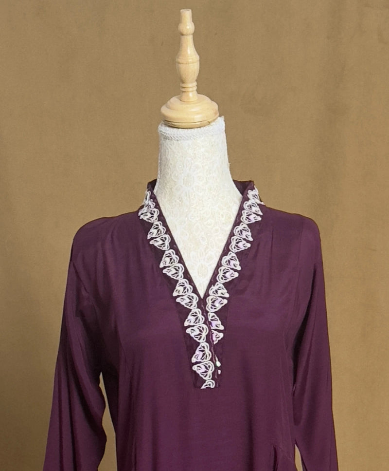 Purple blouse with white lace details on a mannequin against a brown background