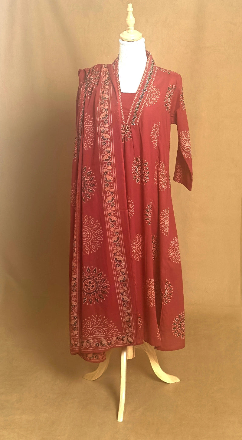 Red embroidered traditional outfit on a mannequin against a beige background