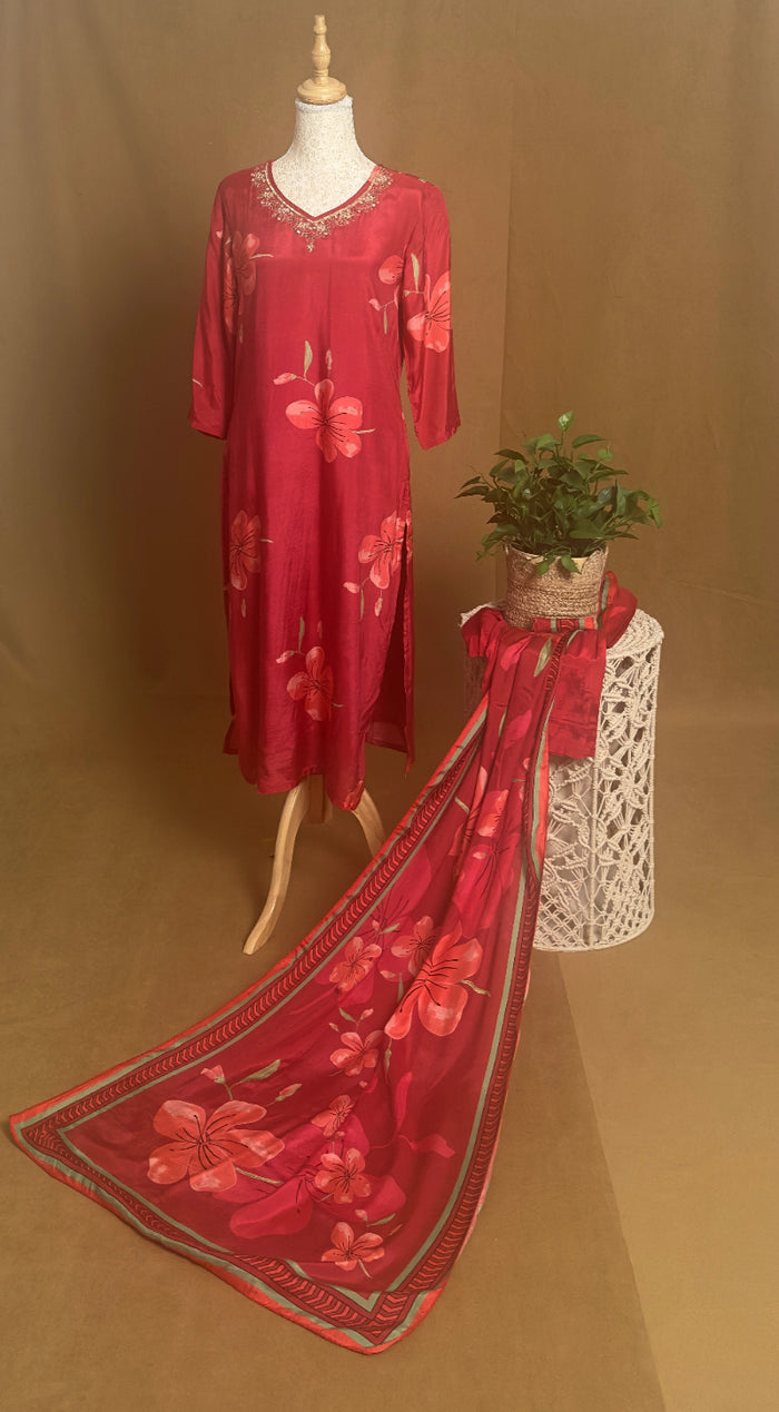 Red floral dress on a mannequin with a matching scarf on a brown background