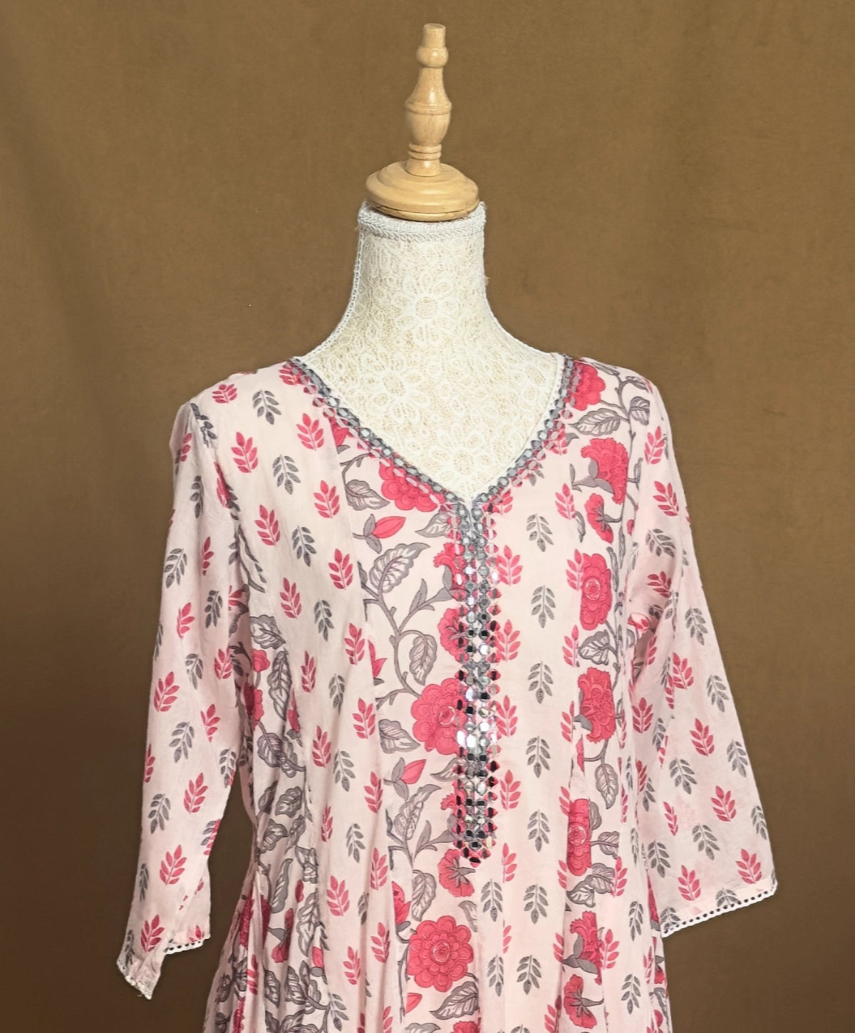 Floral patterned top on a mannequin against a brown background