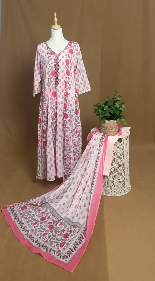 Long floral dress with matching scarf on a mannequin against a brown background
