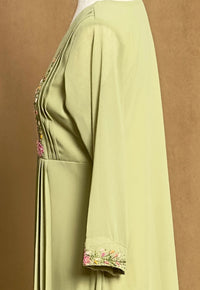 Light green dress with floral embroidery on a brown background