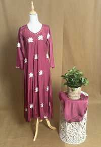 Mauve dress with white floral patterns on a mannequin against a brown background
