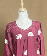 Maroon top with white floral patterns on a mannequin against a beige background