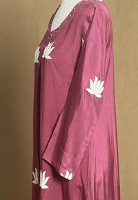 Maroon dress with white floral patterns on a brown background