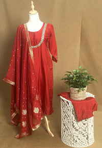 Red traditional outfit with matching dupatta on a mannequin against a brown background