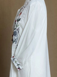 White garment with floral embroidery on a brown background