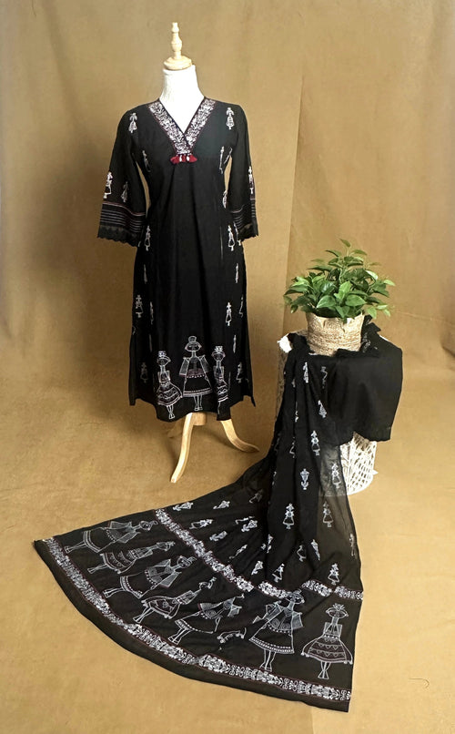 Black dress with white patterns on a mannequin against a brown background