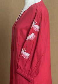 Red garment with white embroidery on a brown background