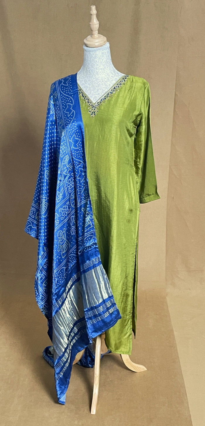 Mannequin wearing a green dress with a blue dupatta on a brown background