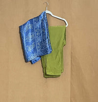 Blue bandana with white patterns and green tank top on a hanger against a brown background