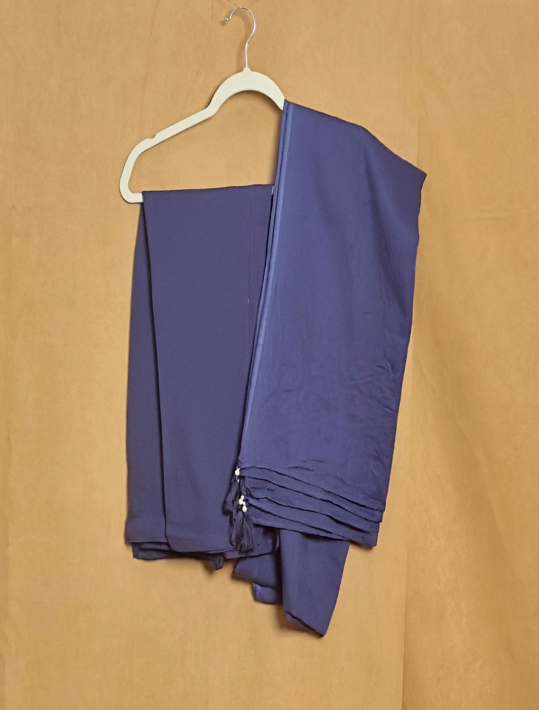 Purple fabric on a white hanger against a beige background