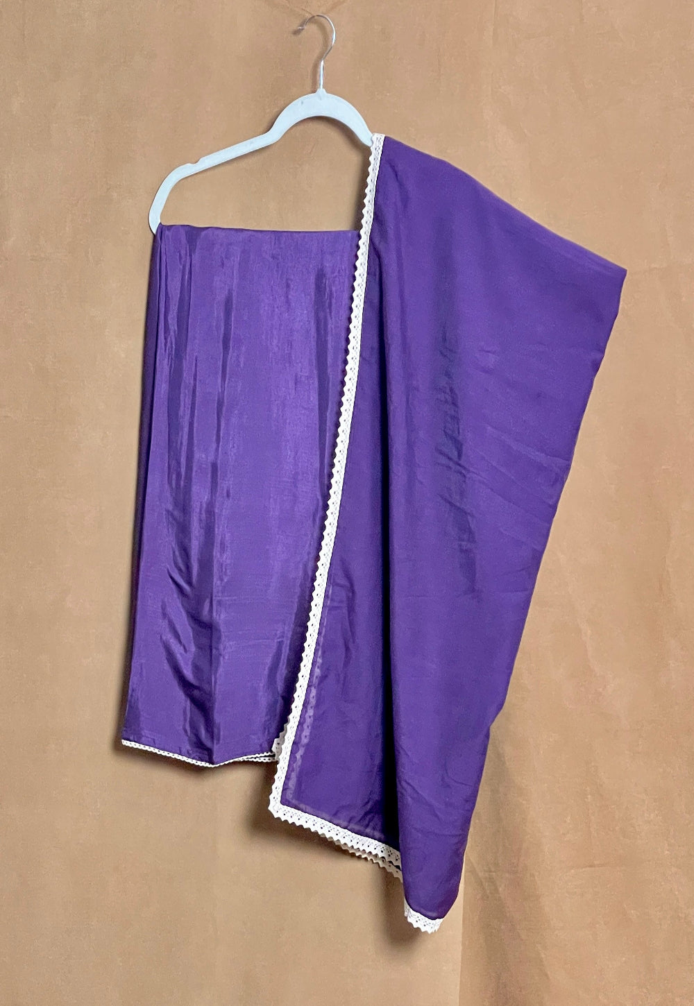 Purple fabric with white trim on a beige background