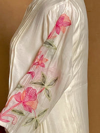 White fabric with pink floral embroidery on a brown background