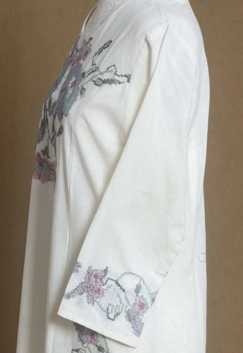 White garment with floral embroidery on a plain background